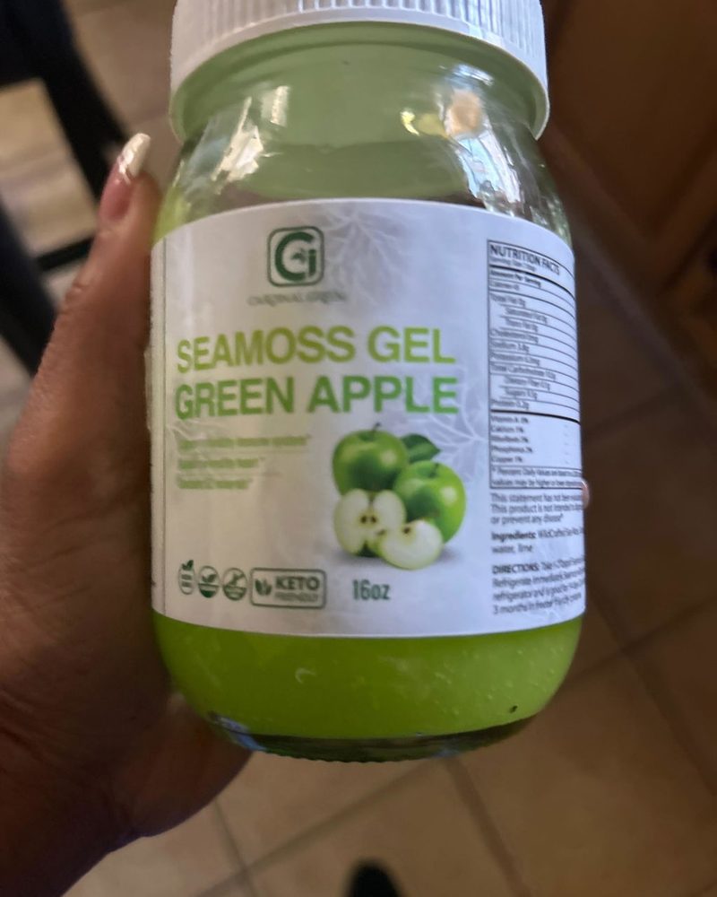 A jar of CGI-Green Green Apple SeaMoss Gel held in a customer's hand, photographed by Theresa Johnson